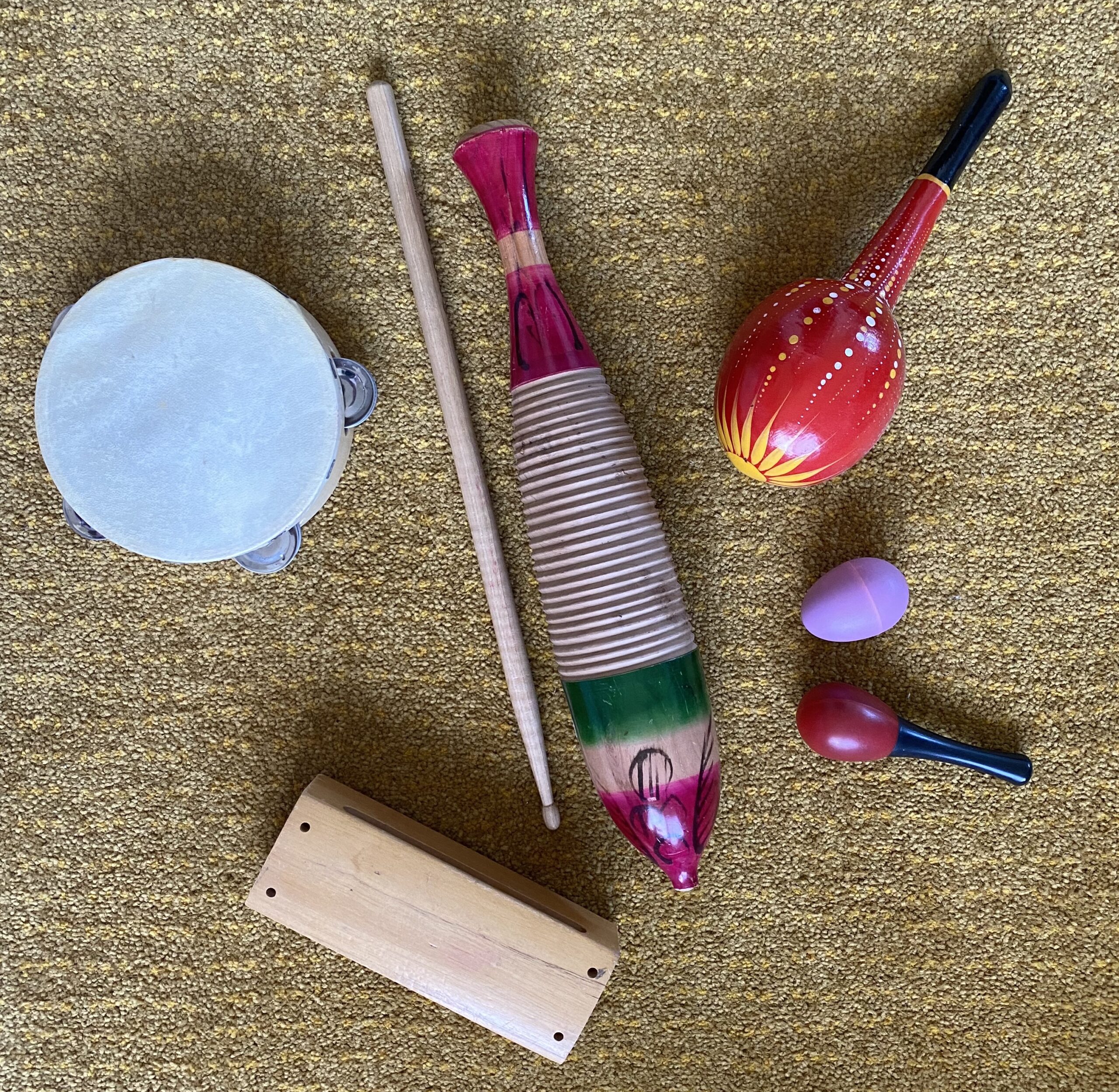 Various percussion instruments lying on a carpeted background